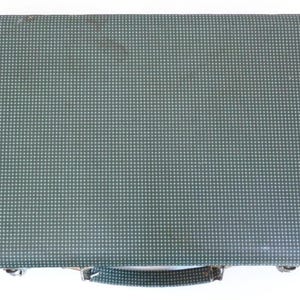 May include: A vintage green briefcase with a repeating white dot pattern. The briefcase has a handle and metal clasps. The exterior shows signs of wear, suggesting it is a used item.
