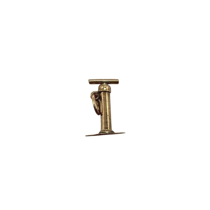 May include: A gold-toned metal charm shaped like a vintage hand pump. The charm features a vertical cylindrical body with a horizontal handle at the top and a flat circular base at the bottom. A small jump ring is attached to the side of the pump.