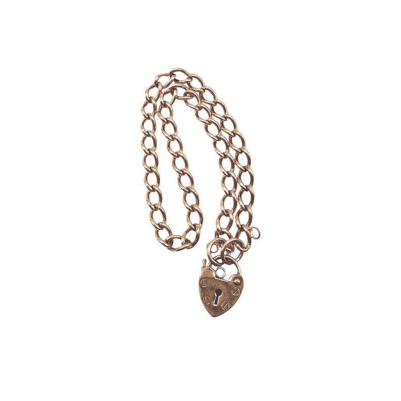 May include: A gold-colored chain necklace with a heart-shaped padlock clasp. The chain is made of oval links, and the padlock has a keyhole. The necklace is displayed against a white background.