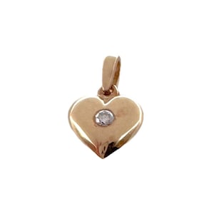 May include: A gold heart-shaped pendant with a small diamond in the center.