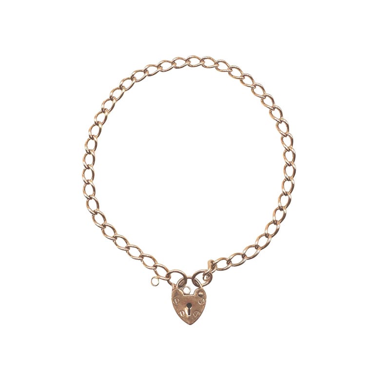 May include: A gold-colored chain bracelet with a heart-shaped padlock clasp. The bracelet features a series of oval links forming a circular shape. The heart-shaped padlock has a keyhole and decorative details.