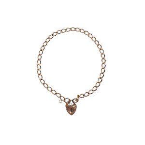 May include: A gold-colored necklace with a heart-shaped padlock clasp. The chain is made of oval links. The necklace is displayed on a white background. The padlock has a keyhole and decorative details.