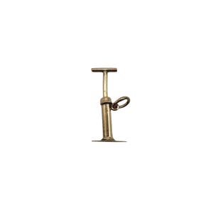 May include: A gold-toned metal charm shaped like a manual air pump. The charm features a vertical cylindrical body with a flat base, a T-shaped handle at the top, and a small circular jump ring attached to the side for hanging on a chain or bracelet.