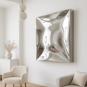 Könnte beinhalten: Ein modernes Wohnzimmer mit einem großen, abstrakten, silbernen Wandkunstwerk. Das Kunstwerk hat eine wellenförmige, reflektierende Oberfläche. Der Raum verfügt außerdem über ein beiges Sofa, einen Sessel und einen runden Holztisch.