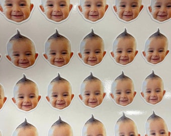 May include: Sheet of stickers featuring smiling baby faces with a distinctive mohawk hairstyle. The stickers are white with a die-cut edge, and the baby's skin tone is light. The image is a close-up of multiple stickers.
