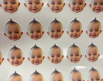 May include: A sheet of stickers featuring a smiling baby with a spiky hairstyle. The stickers are printed on white paper and are arranged in a grid pattern.