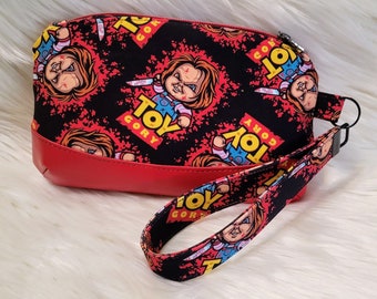 Handmade wristlet clutch with removal strap, horror themed custom fabric, Chucky inspired clematis wristlet
