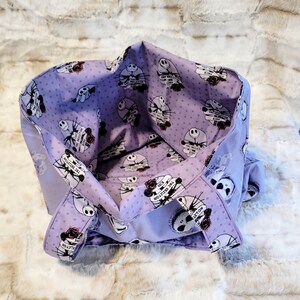 May include: Purple tote bag with a white polka dot pattern and a repeated image of Jack Skellington from The Nightmare Before Christmas. The text "The Skeleton King" is repeated on the bag.