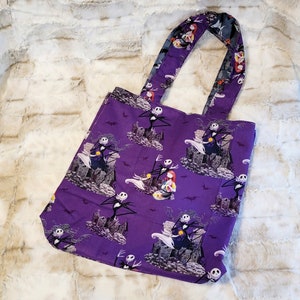May include: Purple tote bag with a repeating pattern of Jack Skellington and Sally from The Nightmare Before Christmas. The bag has two fabric handles.