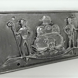 May include: A silver metal Pennsylvania license plate featuring the state seal with the inscription "Liberty and Independence".