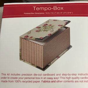 May include: A Tempo-Box craft kit featuring a floral patterned lid and a striped base. The finished box dimensions are 12.5 cm by 7.5 cm by 7 cm. The kit includes precision die-cut cardboard and step-by-step instructions to create a personal box. The cardboard is made from 100% recycled paper.