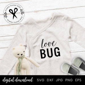 May include: A white onesie with the text "love BUG" in black lettering. The onesie is on a white wooden background with a small stuffed animal and two pairs of shoes.