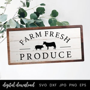 Op de afbeelding: Een wit houten bord met een bruin frame, met de tekst "FARM FRESH PRODUCE" in zwarte letters, met een koe en varken silhouet in het midden.