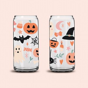 May include: Two clear glass can-shaped cups with Halloween-themed designs. The designs include pumpkins, bats, ghosts, candy corn, stars, and spiderwebs. The cups are perfect for serving drinks at a Halloween party.
