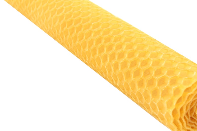 Puede incluir: Un rollo de vela de cera de abeja amarilla en forma de panal. La vela est&aacute; hecha de cera de abeja natural y tiene un patr&oacute;n hexagonal.