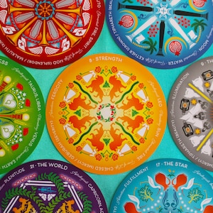 May include: A set of 10 round tarot cards with colorful mandala designs. Each card features a different tarot symbol and astrological sign. The cards are printed on a white background with black text.