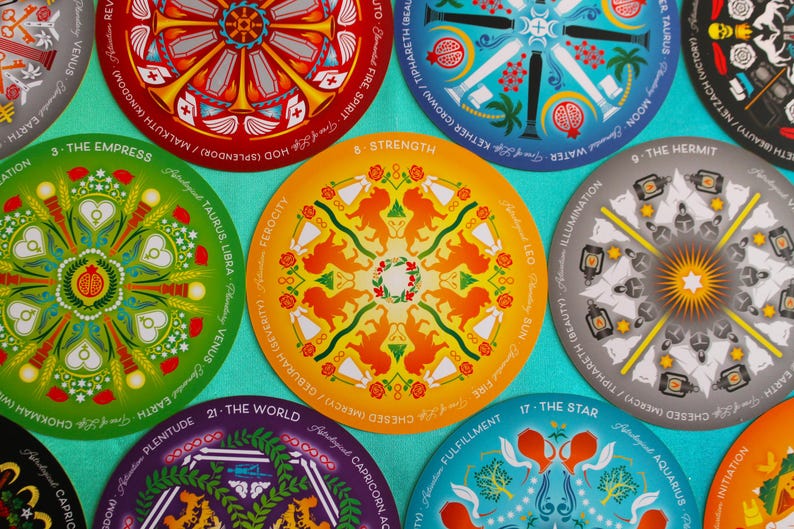 May include: A set of 10 round tarot cards with colorful mandala designs. Each card features a different tarot symbol and astrological sign. The cards are printed on a white background with black text.