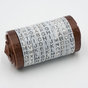 May include: A brown metal cylinder with multiple rotating discs, each with the alphabet printed on it. The cylinder is a letter-based cipher device.