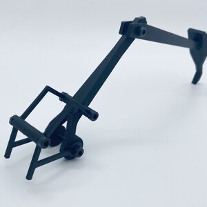 May include: Black plastic toy excavator with a rotating arm and a claw.