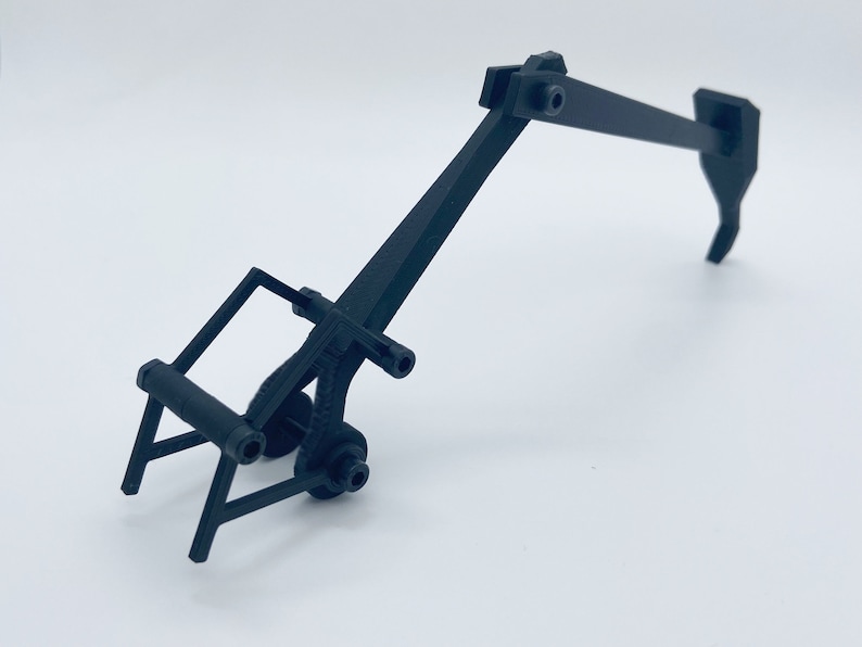 May include: Black plastic toy excavator with a rotating arm and a claw.