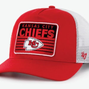 May include: Red and white trucker hat with a black and white patch that says "Kansas City Chiefs" with a red and white arrowhead logo. The hat has a white mesh back.