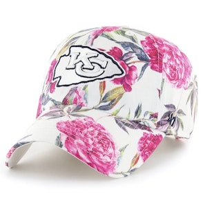 May include: White baseball cap with a floral print featuring pink flowers and green leaves. The front of the cap has a white patch with a black outline and the letters "KC" in black.