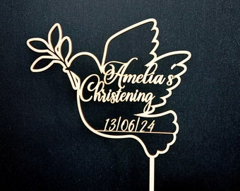 May include: Wooden dove cake topper with a branch and leaves, personalized with the text "Amelia's Christening 13/06/24".