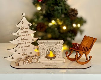 Puede incluir: Decoración navideña de madera con una chimenea, una mecedora y un árbol de Navidad. El árbol tiene un mensaje que dice "Porque alguien que amamos está en el cielo, hay un poco de cielo en nuestro hogar".