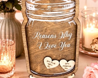 May include: A wooden jar-shaped sign with a dark brown finish featuring white text that reads Reasons Why I Love You. The sign includes a clear front panel and two small wooden hearts inside with the text you look after me and you support me.