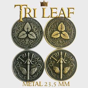 Könnte beinhalten: Vier Metallmünzen mit dem Text "TRI LEAF" und "METAL 23,5 MM". Zwei Münzen zeigen ein dreiblättriges Design, und zwei ein Schwert mit Flügeln. Die Münzen sind in Silber- und Goldtönen gehalten, mit einem Durchmesser von 23,5 mm.