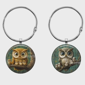May include: Two circular silver-toned keychains featuring glass cabochons. The left keychain displays a brown owl with three owlets on a branch. The right keychain shows a grey owl with three owlets on a branch against a green plaid background.