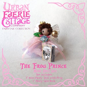 May include: A pink fairy doll with brown hair and a crown, holding a book titled "The Frog Prince". The doll is 7.6 cm tall and comes with a 2.5 cm fairy tale book.