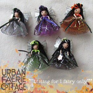 May include: Five handmade Halloween fairy dolls with black hair and spiderweb wings. Each doll is wearing a different colour dress: grey, purple, green, black, and orange. The dolls are all wearing black ribbon belts and have silver glitter accents. The text "***Listing for 1 fairy only***" is visible at the bottom of the image.