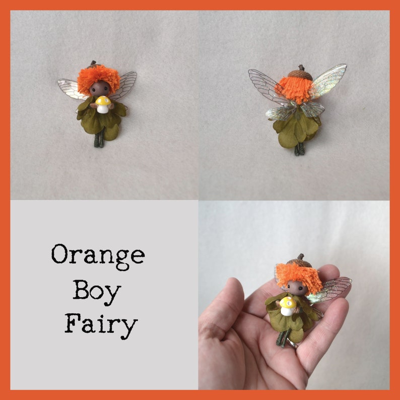 Op de afbeelding: Oranje jongensfeepop met bruine huid, oranje haar en groene vleugels die een gele paddenstoel vasthouden. De fee is gemaakt van stof en heeft een houten hoofd.