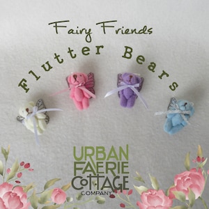 Peut inclure: Quatre petits ours en peluche avec des ailes et des rubans. Les ours sont rose, violet, bleu et crème. Le texte "Fairy Friends Flutter Bears" est au-dessus des ours. Le texte "Urban Faerie Cottage Company" est en dessous des ours.