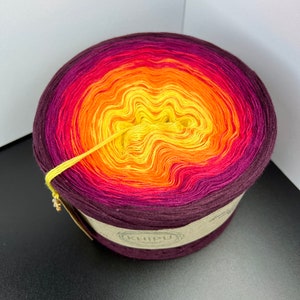 May include: A skein of yarn in a gradient of colors from deep purple to yellow. The yarn is wound into a ball and the label reads "KHIPU".