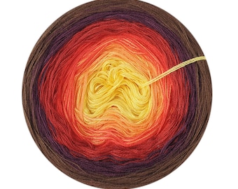 May include: A ball of yarn with a gradient of colors from dark brown to yellow. The yarn is wound into a circle and the center of the ball is visible.