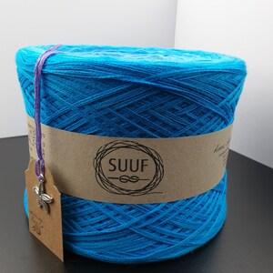 May include: A skein of bright blue yarn with a brown label that says "SUUF" with a knot symbol. The yarn is wrapped around a cardboard tube.