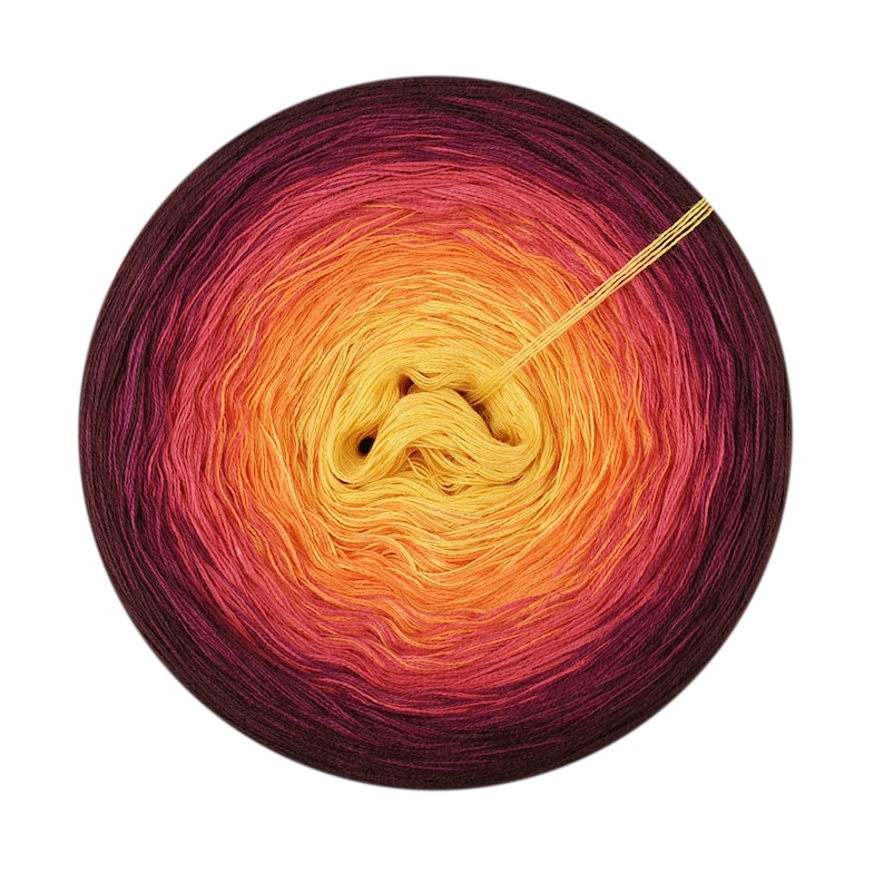 May include: A ball of yarn with a gradient of colors from dark purple to yellow. The yarn is wound into a circle and the end of the yarn is visible.
