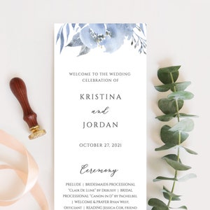 May include: Wedding ceremony program with blue watercolor floral design. The program lists the wedding date as October 27, 2021, and includes the names Kristina and Jordan.