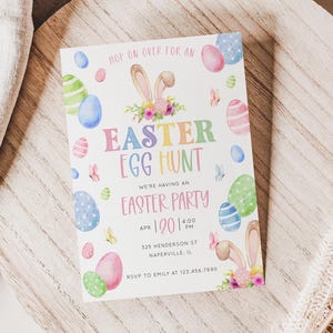 Op de afbeelding: Een uitnodiging voor een paaseierenjacht in pastelkleuren. De uitnodiging toont konijnenoren, kleurrijke eieren en vlinders. De tekst luidt "Easter Egg Hunt" en "Easter Party" met evenementdetails.