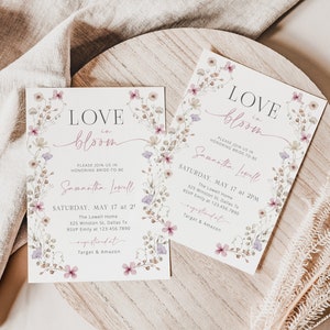 May include: Two floral-themed bridal shower invitations with the text "LOVE in bloom" and the bride-to-be's name, Samantha Lowell. The invitations are on a wooden surface with a beige fabric in the background.