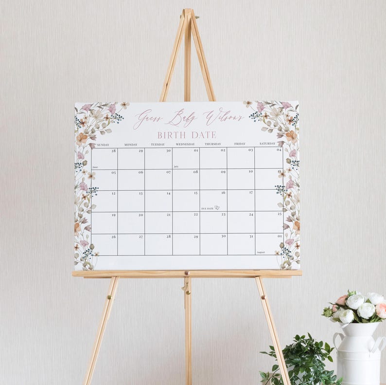 May include: A white calendar with floral borders and the text "Guess Baby's Welcoming Birth Date" printed in pink. The calendar has the days of the week labelled and the numbers 1 through 31.