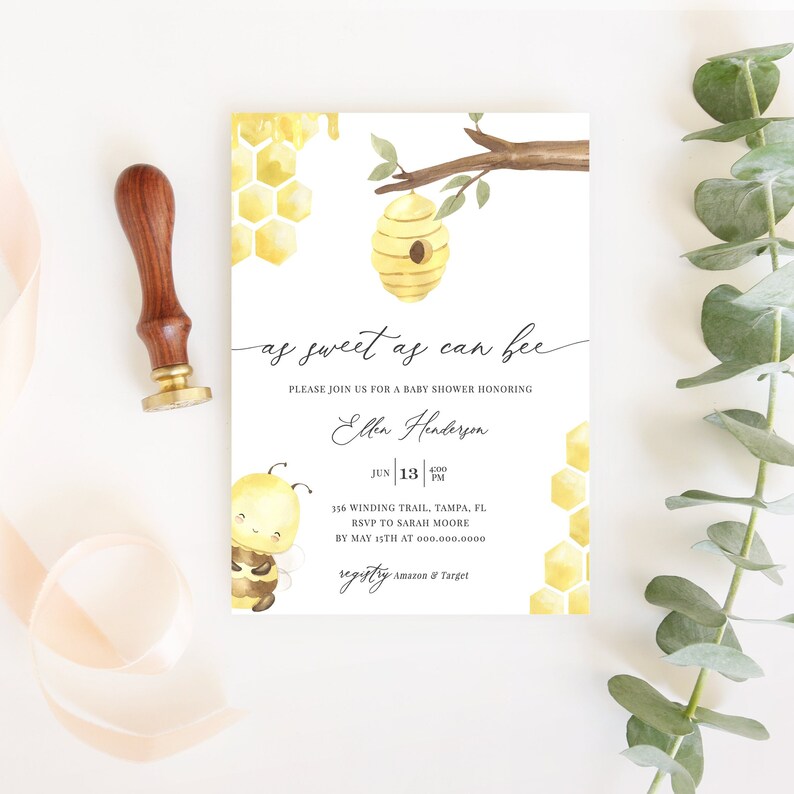 May include: A baby shower invitation with a watercolor design featuring a bee, honeycomb, and a beehive. The invitation reads "as sweet as can bee" and includes event details. A wooden stamp and ribbon are on the left.
