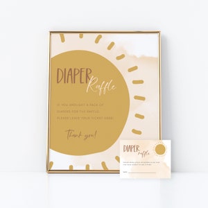May include: A printable sign for a diaper raffle. The sign features a yellow sun with a brown watercolor background. The text on the sign reads "Diaper Raffle" and "If you brought a pack of diapers for the raffle, please leave your ticket here! Thank you!"