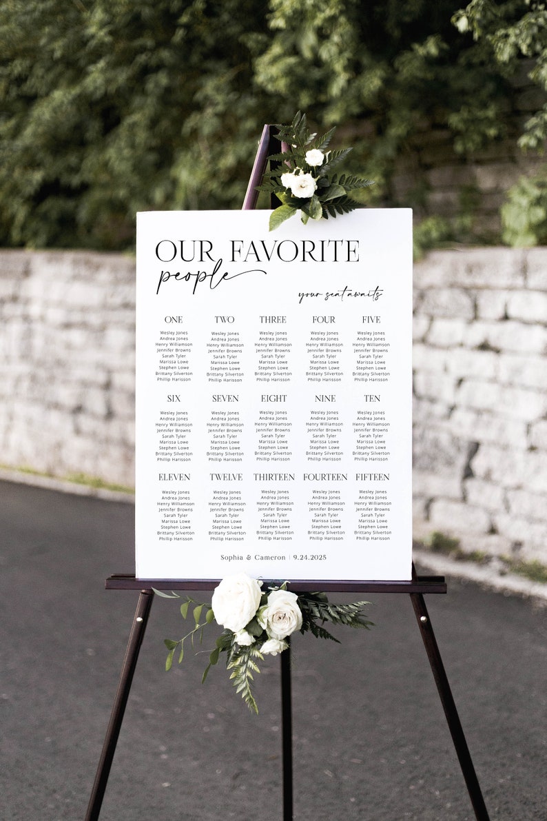 May include: A white seating chart with black text for a wedding reception. The chart is titled "Our Favorite People" and lists names for each table number from one to fifteen. The bottom of the chart reads "Sophia & Cameron 9.24.2025".