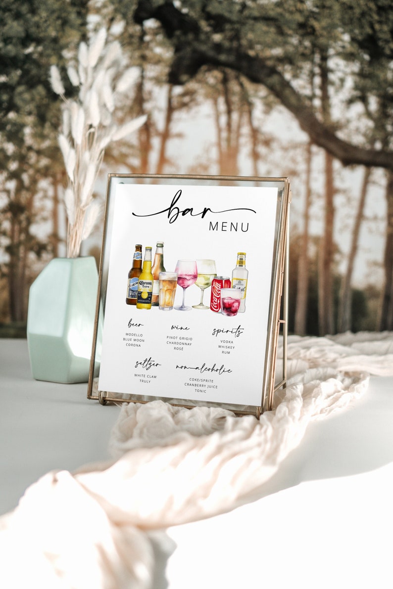Op de afbeelding: Een gouden gelijst barmenu-bord met een witte achtergrond. Het bord bevat een aquarel-illustratie van verschillende dranken, waaronder bier, wijn, sterke drank en niet-alcoholische dranken. Het menu vermeldt de specifieke soorten dranken die in elke categorie beschikbaar zijn.