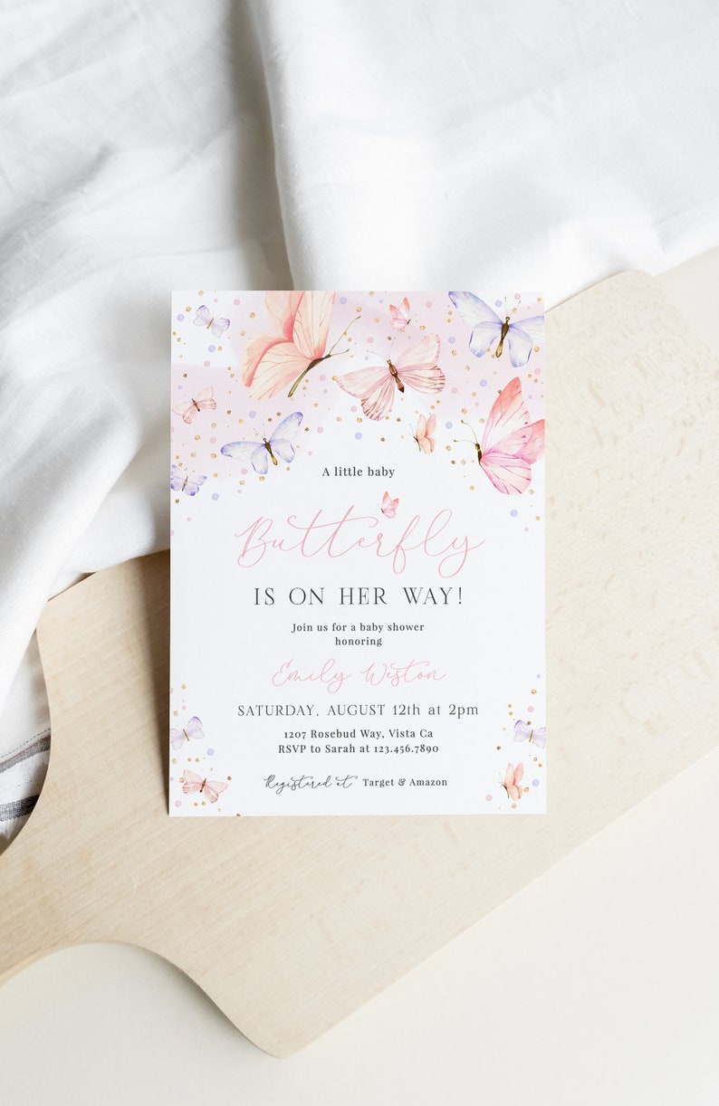 Puede incluir: Una invitaci&oacute;n de baby shower rosa y blanca con un dise&ntilde;o de mariposa. La invitaci&oacute;n dice "&iexcl;Un peque&ntilde;o beb&eacute; Mariposa est&aacute; en camino!" e incluye la fecha, la hora y el lugar de la ducha. Tambi&eacute;n dice "RSVP a Sarah al 123.456.7890" y "Registrado en Target & Amazon".