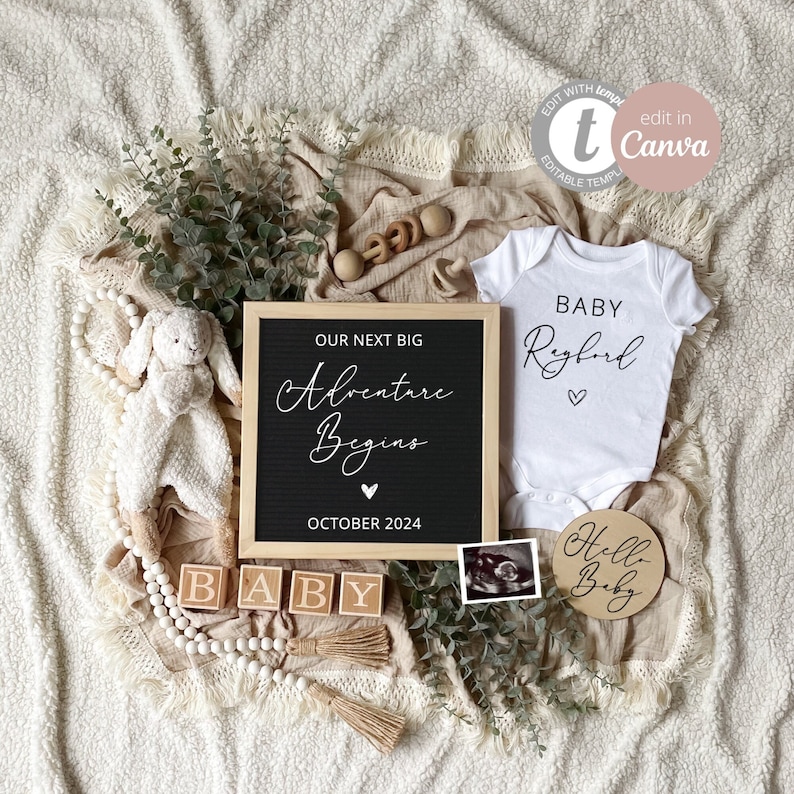 May include: A white onesie with the text "BABY Ryford" in black script font and a small heart. A black letter board with the text "OUR NEXT BIG Adventure Begins" in white script font and "OCTOBER 2024" in black text. A wooden sign with the text "Hello Baby" in white text. Wooden blocks spelling "BABY". A white and brown beaded garland. A small stuffed animal. A framed ultrasound image.