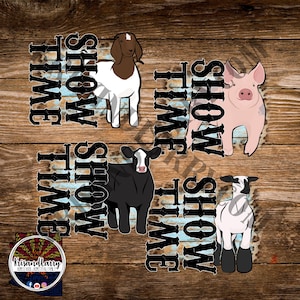 May include: A digital graphic featuring a goat, pig, cow, and lamb, with the words "Show Time" in a vertical, distressed font. The animals are in a cartoon style, with a rustic wood background.